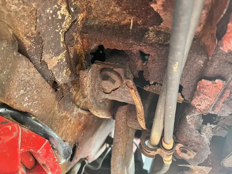 Rusted trailing arm mount before repair