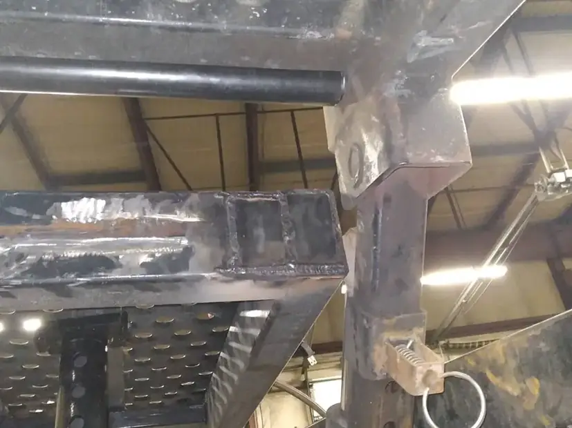Welding underneath a trailer deck in the shop